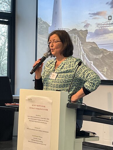 Irene Krebs steht am Rednerpult und spricht via Mikro.