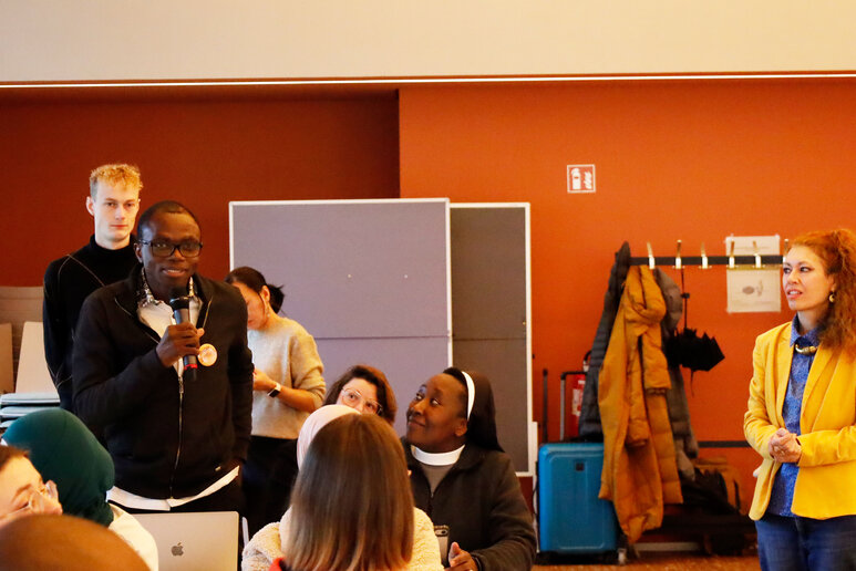 Teilnehmende stehen in einem Raum und tauschen sich aus.