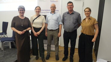 Gruppenfoto von fünf Personen vor einem Roll-Up mit den Logos der Katholischen Hochschule NRW (katho) und der Bürgerstiftung Rheinviertel. 