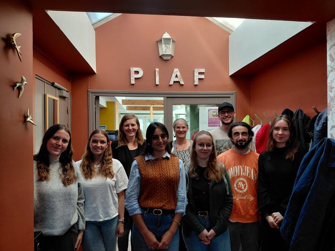 Deutsche und französische Kursteilnehmende stehen in einer Gruppe zusammen und sind fröhlich. 