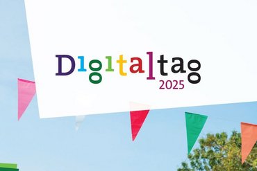 Das Logo des Digitaltags erscheint vor blauem Himmel und einer Wimpelgirlande.