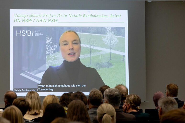 Prof.in Dr.in Natalie Bartholomäus vom Beirat HN NRW / NAW.NRW ist auf einem Monitor zu sehen.