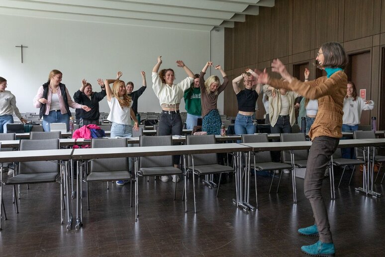Diane Samuels macht eine Aktion gemeinsam mit den Studierenden. Dabei stehen alle und machen Bewegungen mit ihren Armen.