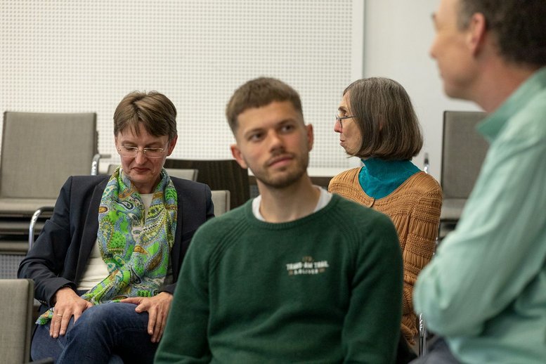 Auf den Bild sind verschiedene Personen miteinader im Gespräch.
