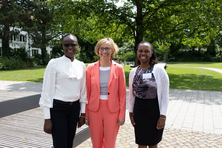 Drei Personen stehen nebeneinander und lachen. Sie sind fröhlich, Teil der International Week zu sein. 