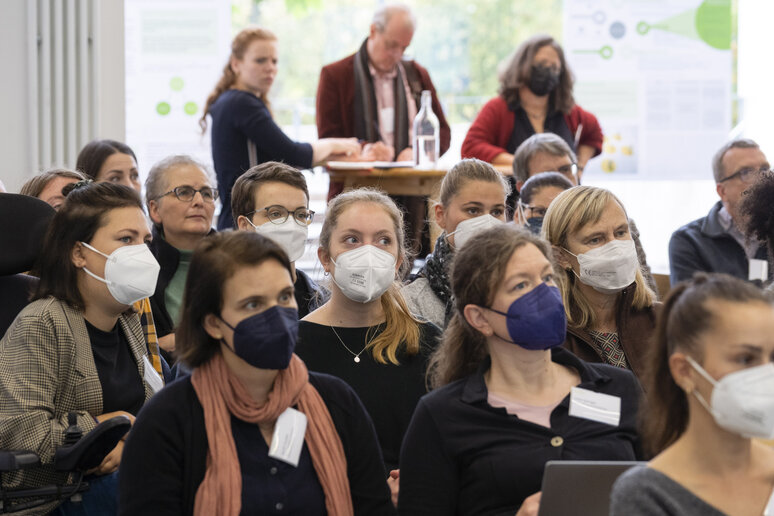 Menschen in Sitzreihen hören zu