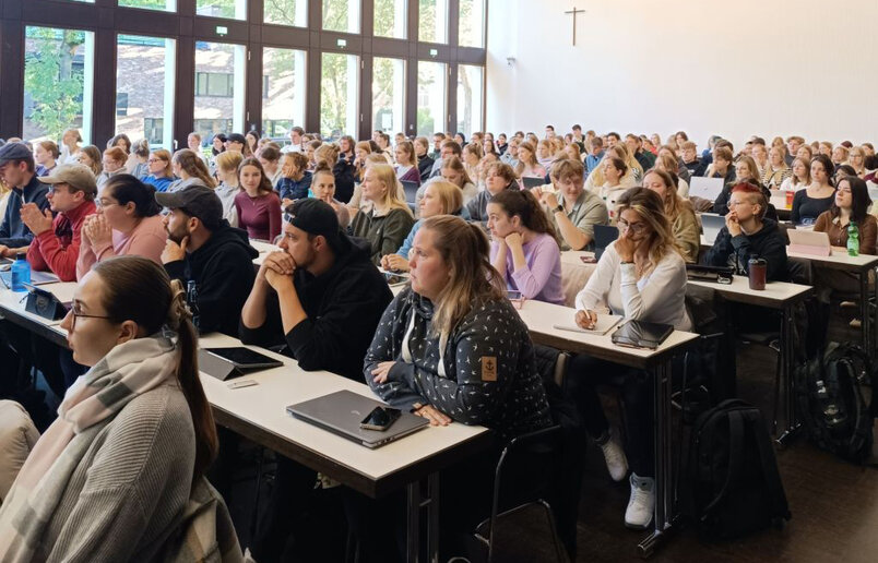 Die neuen BA-Studierenden Soziale Arbeit hören im Hörsaal interessiert einem Vortrag zu.