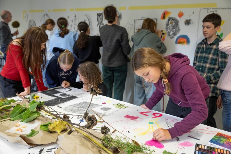 Schüler:innen malen mit Kohle.
