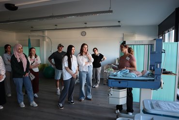 Frau Prof.in Wödy erklärt mehreren Teilnehmenden im Skillslab eine praktische Übung am Simulationsmodell