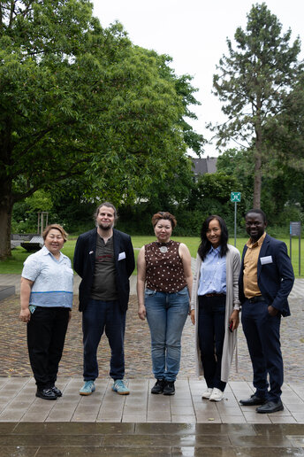 Fünf Personen stehen neben einander und freuen sich, Teil der Stadtführung in Paderborn zu sein. 