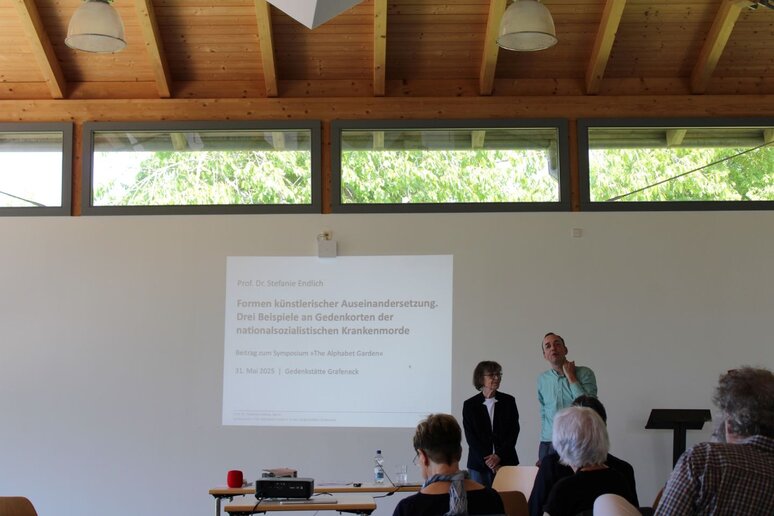 Künstlerin Stefanie Endlich und Projektleiter Jochen Bonz stehen vorne vor dem Publikum.