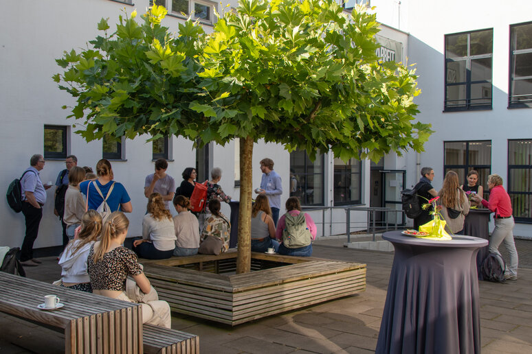 Die Menschen versammeln sich im Innenhof der katho