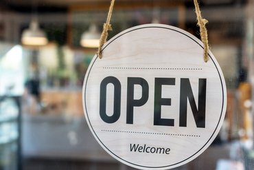 Schild mit der Aufschrift "OPEN" und "Welcome"