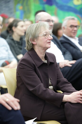 Liane Schirra Weirich sitzt in der ersten Reihe der vollbesetzen Aula und hört den Rednern zu-u