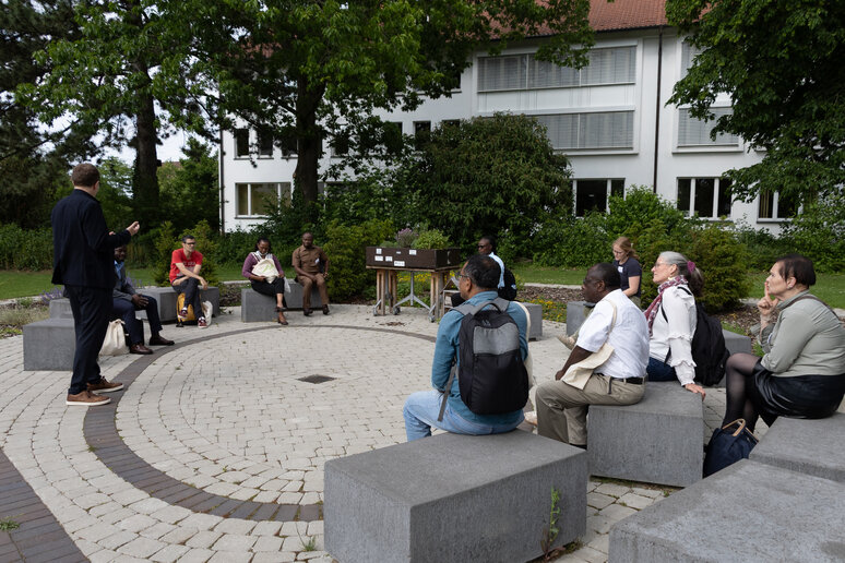 Eine Gruppe von Menschen sitzt im Lerngarten in Paderborn und es wird über den Garten gesprochen. 