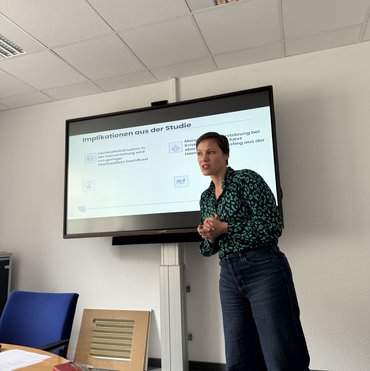 Professorin Karla Verlinden steht im Seminarraum vor einem Monitor und spricht.