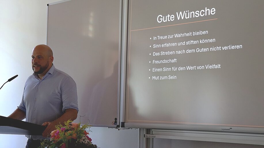 Der Rektor der Theologischen Fakultät steht am Rednerpult und hält eine Rede.