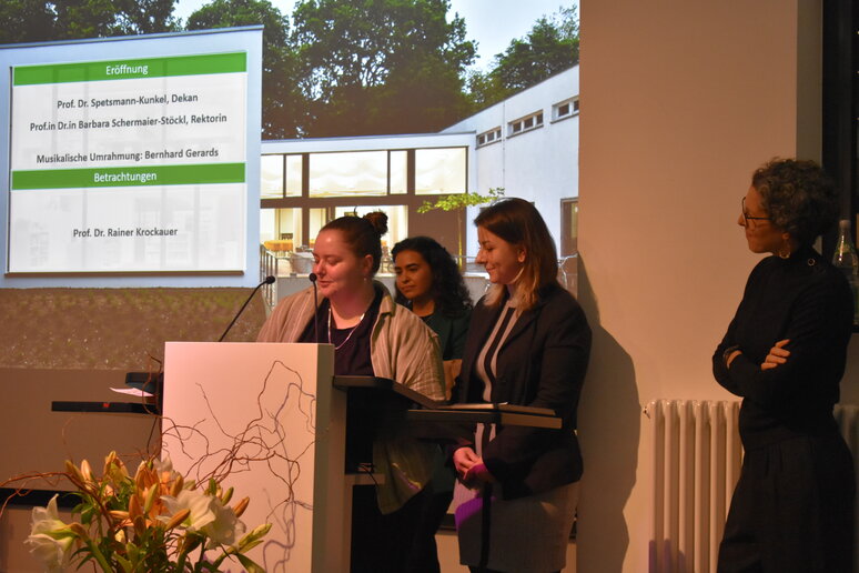 Mehrere Menschen am Rednerpult