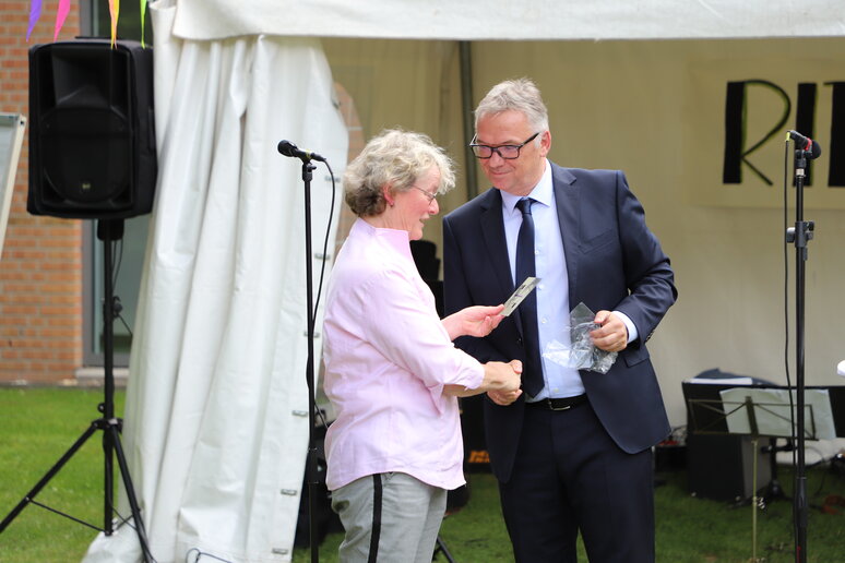 Herr Hobelsberger gratuliert Frau Paß und überreicht ihr eine Karte.