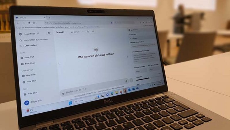 Ein geöffneter Laptop steht in einem Seminarraum. Auf dem Bildschirm ist LibreChat zu sehen.