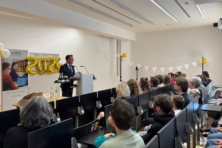 Auf dem Bild sind volle Sitzreihen und der Prodekan am Rednerpult abgebildet