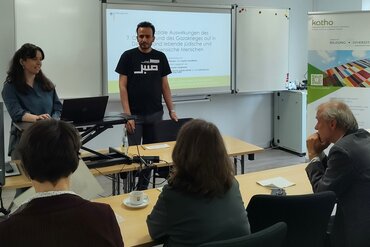 Ein Student und eine Studentin stehen am Redepult, auf der Präsentation hinter ihnen steht: "Soziale Auswirkungen des 7. Oktober und des Gazakrieges auf in Deutschland lebende jüdische und palästinensische Menschen.