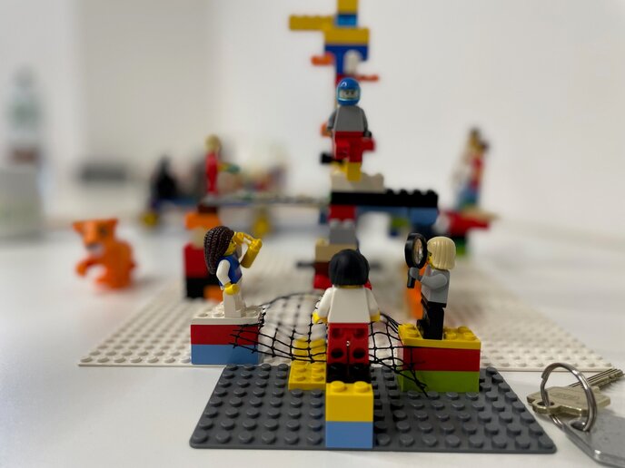 Exemplarische Lego-Serious-Play-Vision mit verschienden Lego-Figuren, die im Kreis stehen