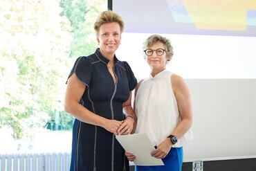 Ina Brandes MdL überreicht Eike Quilling die Ernennungsurkunde für das Amt der Vorstandsvorsitzenden.