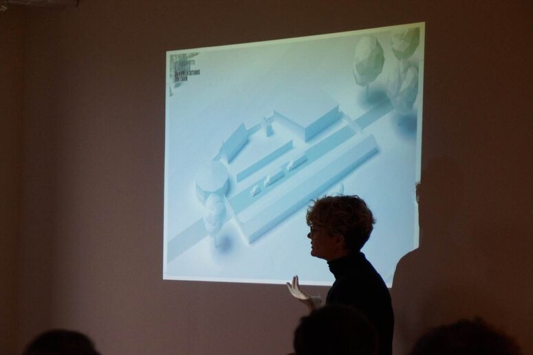 Eine Frau steht vor einer Leinwand und hält einen Vortrag.