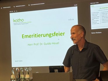 Herr Prof. Dr. Heuel steht an einem Rednerpult und hält eine Ansprache