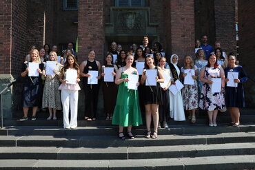 Gruppenfoto der Bachelor-Absolvent_innen 2025/2026 vor dem Haupteingang des Standorts Paderborn