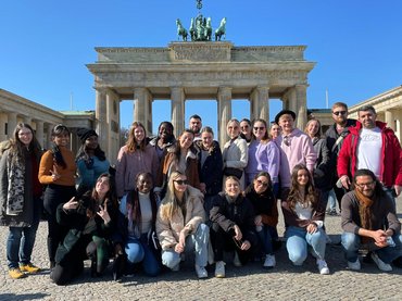 Gruppenbild der internationalen Studierenden mit Mitarbeiter_innen des international Office vor dem Brandenburger Tor.