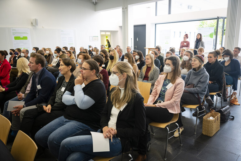 Menschen in Sitzreihen hören zu