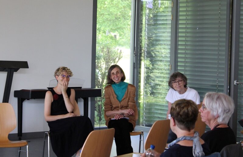 Kathrin Bauer von der Gedenkstätte Grafeneck, Künstlerin Diane Samuel und Stefanie Endlich von der Universität der Künste (UdK) Berlin sitzen und reden.