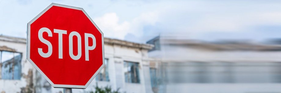 Ein Stop-Schild mit einem alten Gebäude im Hintergrund.