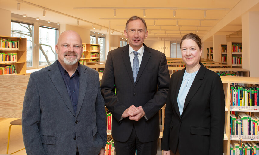 Gruppenfoto in der Bibliothek zeigt Innenarchitekt Andreas Franke, Kanzler Bernward Robrecht und die Leiterin der Hochschulbibliothek Viola Springer.