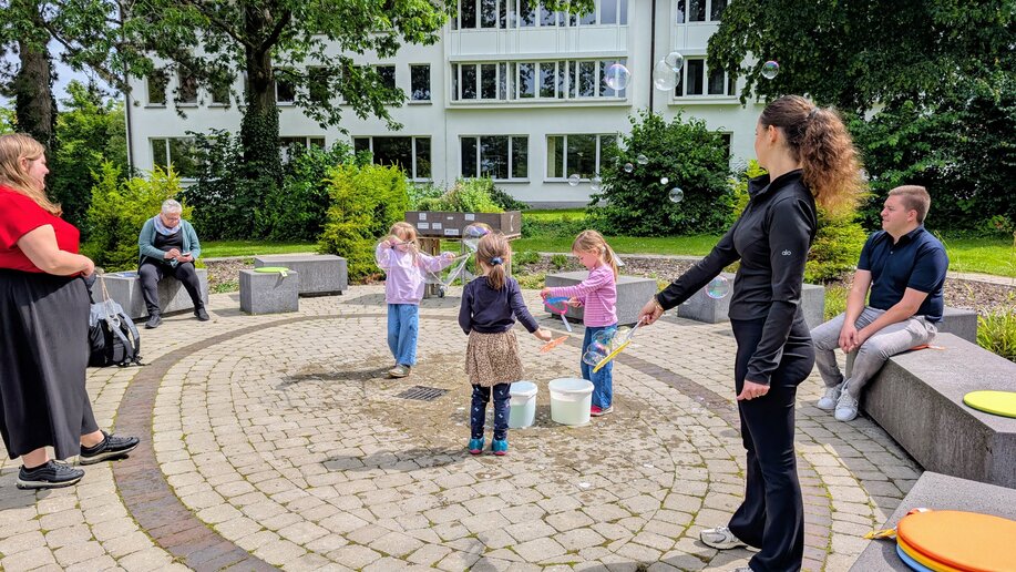 Kinder und Studierende erzeugen Seifenblasen im Lerngarten³