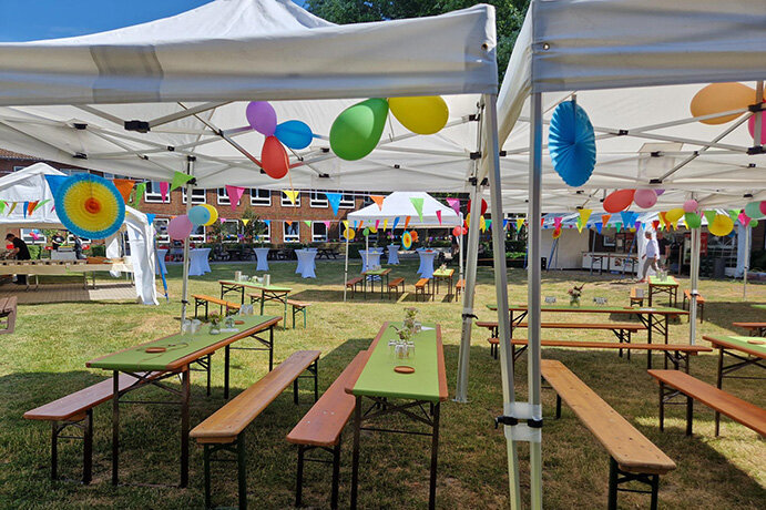 Bierbänke, Pavillons und bunte Dekoration im Innenhof.