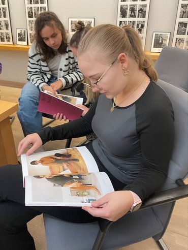 Zwei Studierende schauen sich ein Buch mit Bildern der Künstler an.