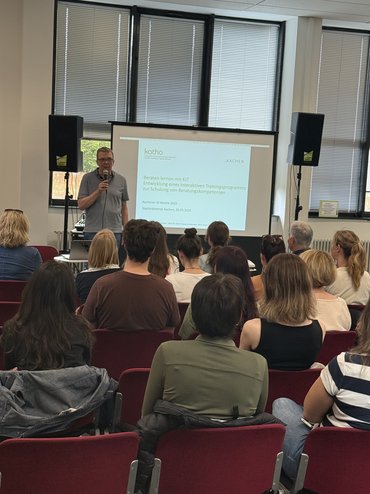 Prof. Lichterfeld steht vor einer Leinwand und moderiert die Veranstaltung.