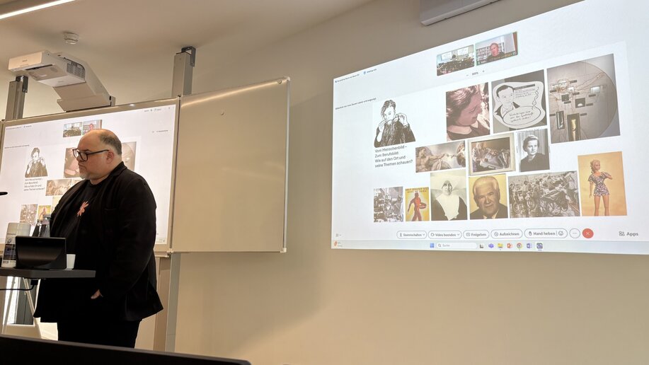 Prof. Dr. Michael Bossle steht im Audimax der katho am Rednerpult und stellt eine Präsentation vor.