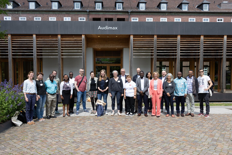 Eine große Gruppe von Personen steht vor dem katho-Gebäude. Die Personen der Gruppe lächen. 