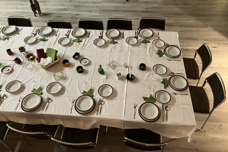 Ein gedeckter Tisch mit Tellern und Tischdecke von oben fotografiert.