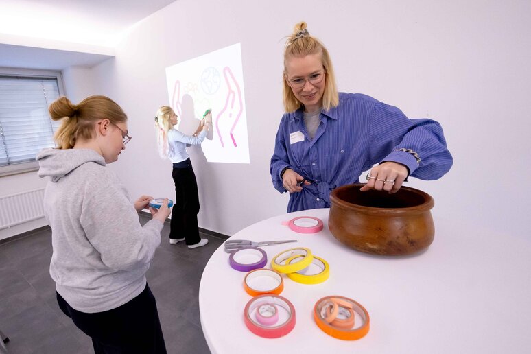 Laura Schlütz (Sustainable Art and Design) steht im Foyer an einem Stehtisch.