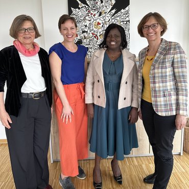 Die Rektorin Rektorin Barbara Schermaier-Stöckl steht in ihrem Büro. An ihrer Seite stehen Prof.in Dr.in Karla Verlinden und Helene Hofmann.