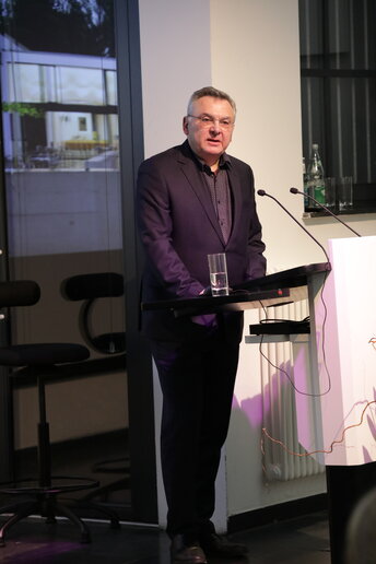 Mann steht am Rednerpult