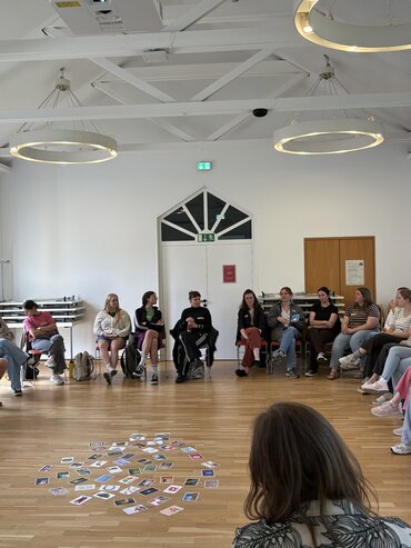 Studierende diskutieren, im Stuhlkreis sitzend.