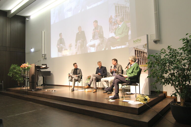 Die Teilnehmenden sitzen auf dem Podium und diskutieren.