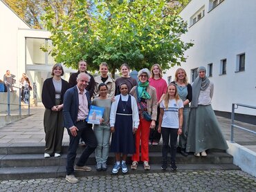 Gruppenbild im Hof der Aachener katho mit zehn Studierenden, einem Professor sowie der Ordensschwester und ihren zwei Begleitpersonen.