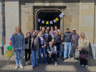 Eine Gruppe Studierende steht vor einem Eingang, links im Bild steht die Seminarleitung